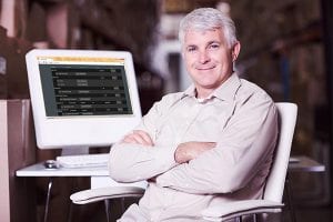 hvac manager using computer against portrait of a positive team sitting at a table